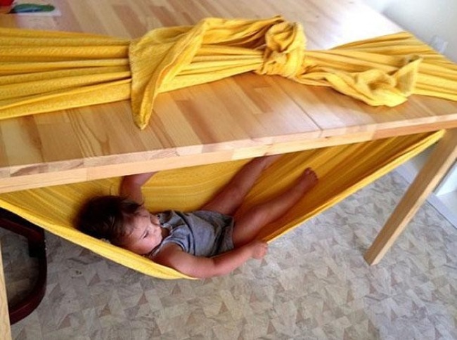 A sturdy table and a table cloth can also make a kid hammock.