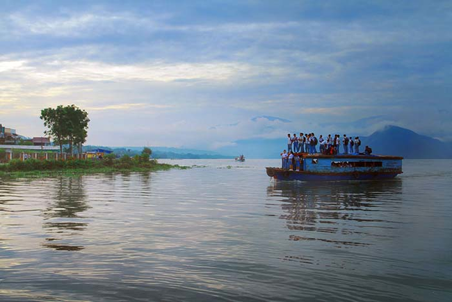 10.) Pangururan, Indonesia - This old looking wooden boat is the way these kids get to school.