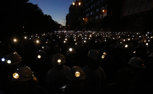 Spanish coal miners hold a night vigil with help from their helmets.