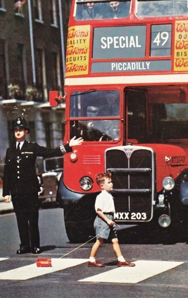 9.) A boy in London in the 1960s with a toy double decker bus.