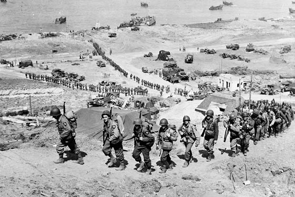 US Army reinforcements march up a hill after landing.