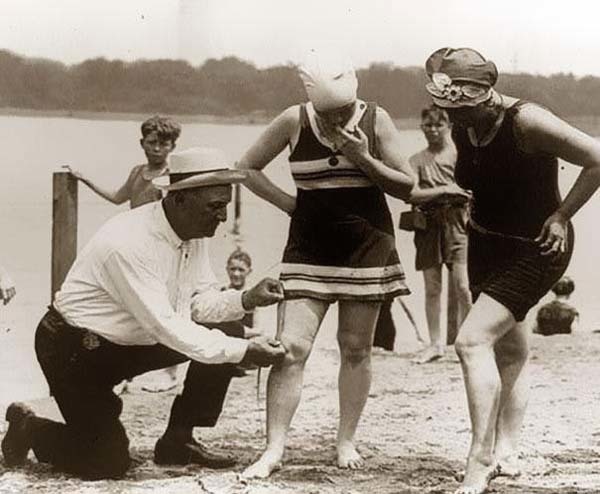 10.) A beach official measures bathing suits to make sure they aren't too short (1920).