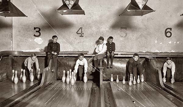 5.) "Pin boys" set up bowling pins while people play games (1914).