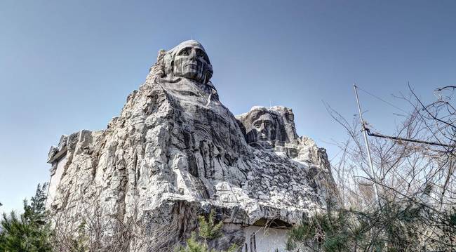 A weathered looking Mt. Rushmore replica.