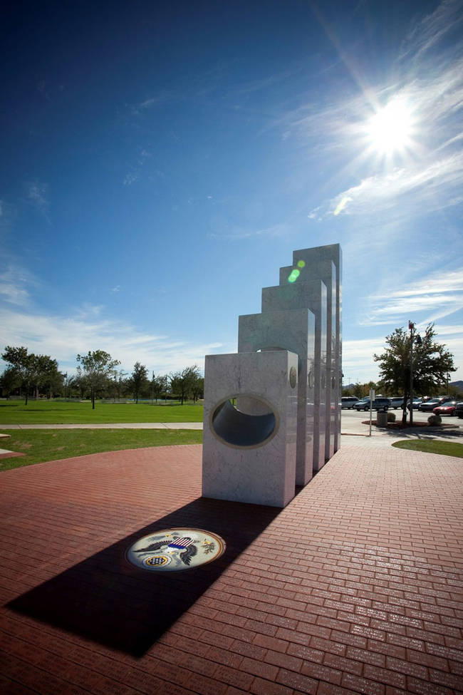 On the red brick around the sunlit Great Seal of the United States the names of 750 Armed Service members.