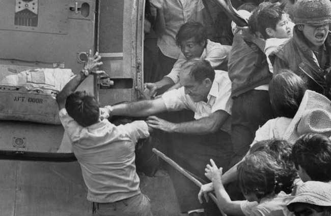 21.) Evacuating Saigon. An American evacuee punches away a South Vietnamese man for a place on the last chopper out of the US embassy (April 30, 1975).