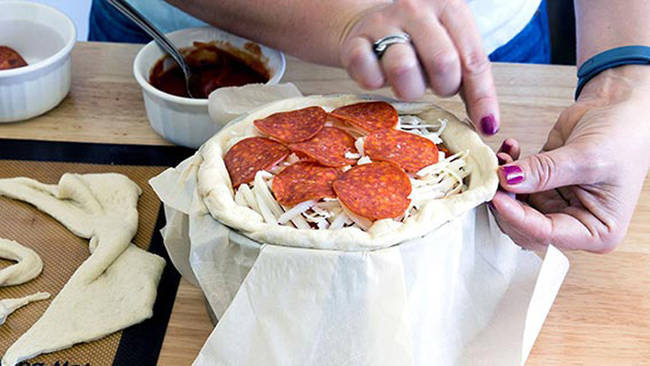 Continue this process until you reach the top of the pan. Roll the overlaying dough up to create a "crust" for your pizza.