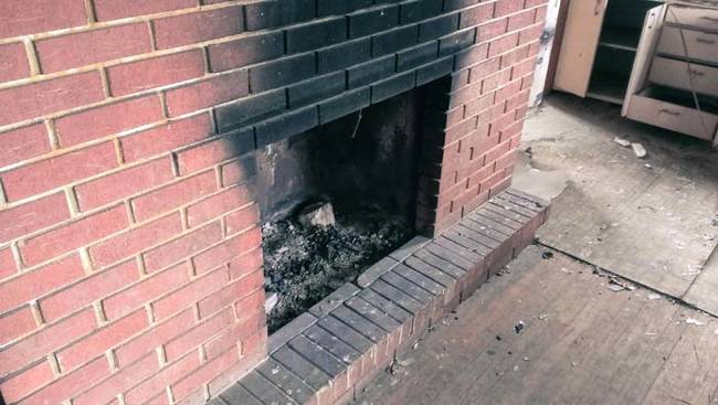 The blackened fireplace in the living room. This appeared to be the only source of heat in the house.