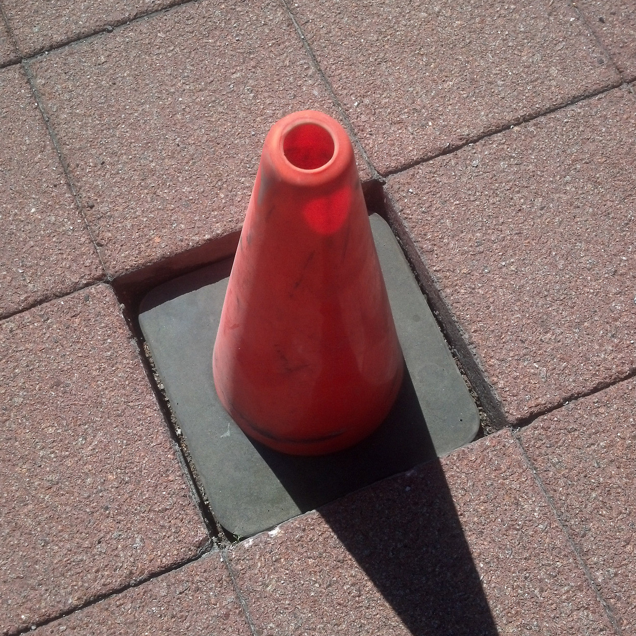 20. A traffic cone fitting flawlessly into a patio.