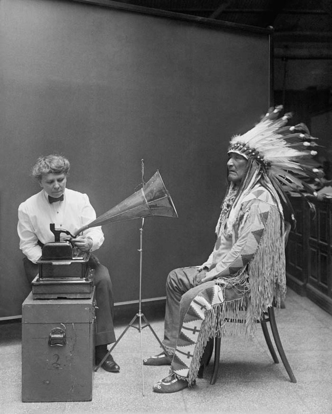 29.) Ethnomusicologist Frances Densmore recording the music of a Blackfoot chief onto a phonograph (1916).