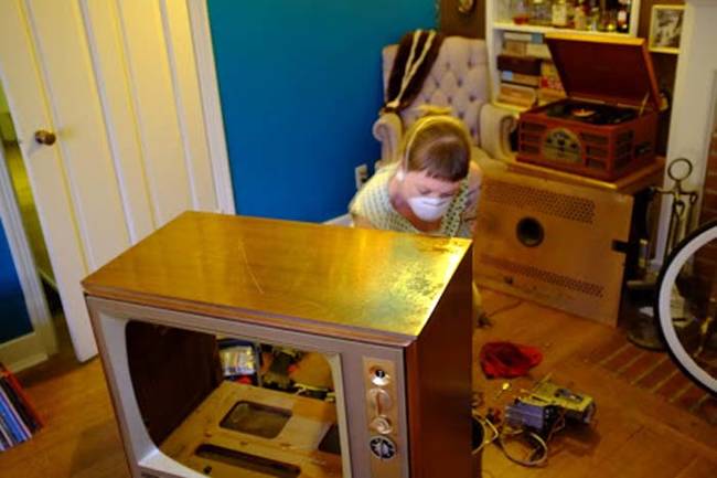 After gutting the television, Val lined the TV with fabric. She added a string of Christmas lights to the top of the TV, to give it the inner glow.