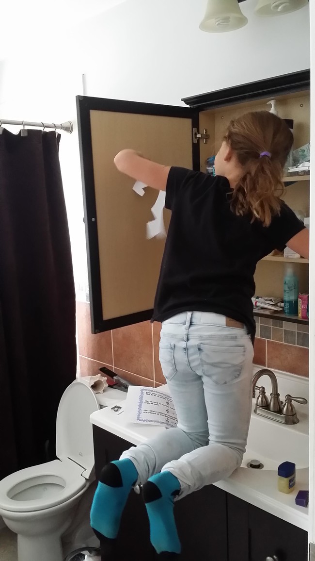 Rachel looking behind the bathroom mirror.