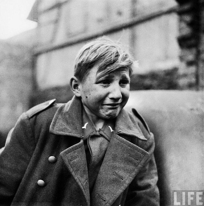 14. Fear - A 15 year old German soldier, Hans-Georg Henke, cries after being captured by the US 9th Army in Rechtenbach, Germany, on April 3, 1945.