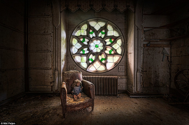 A doll perches on a decaying leather chair in a French 15th century castle, Chateau Clochard.