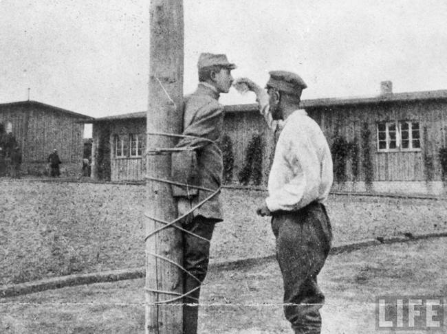 2.) French soldier tied to a stake receives a drink from a fellow POW in 1917.