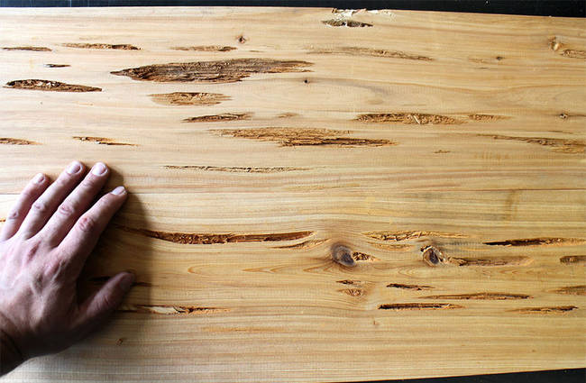 It starts out with Pecky cypress wood. A board of it has naturally occurring depressions and holes that are perfect for the design of the table.