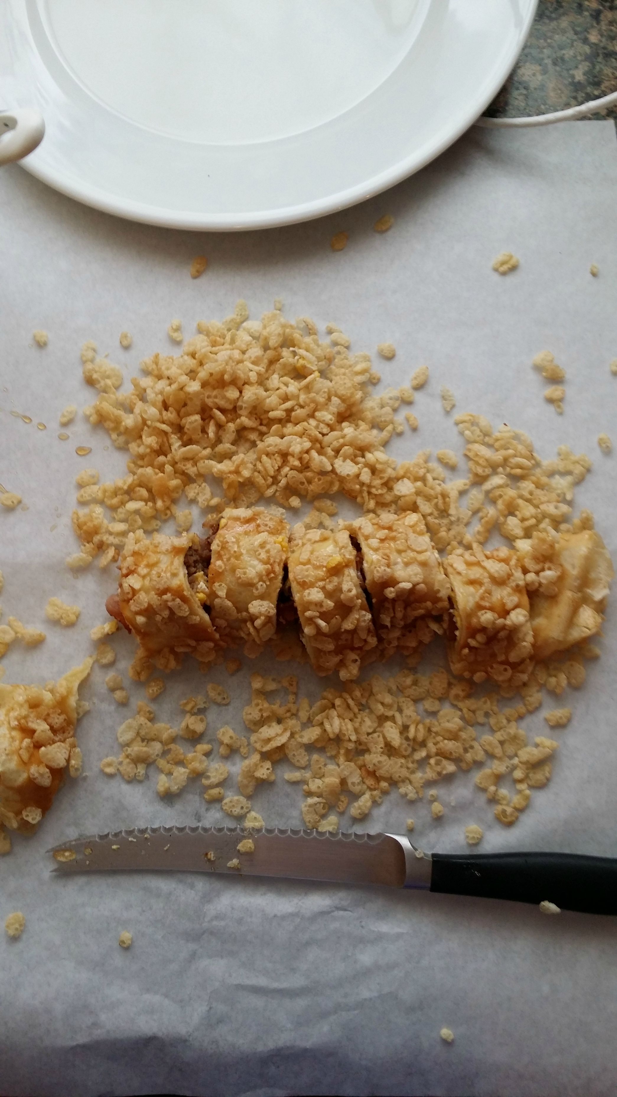 He slices the roll into several smaller pieces, and adds some rice krispies.