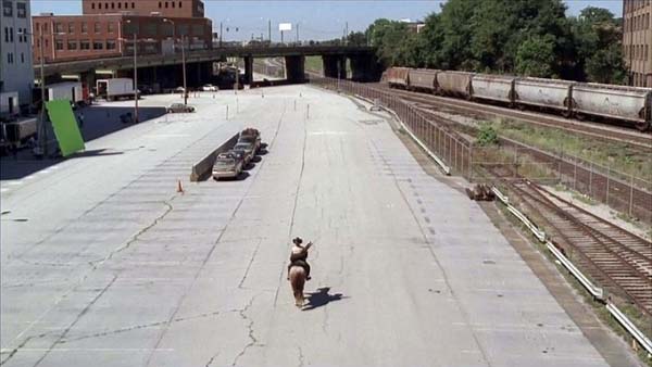 Before: actor Andrew Lincoln riding a horse in a parking lot.