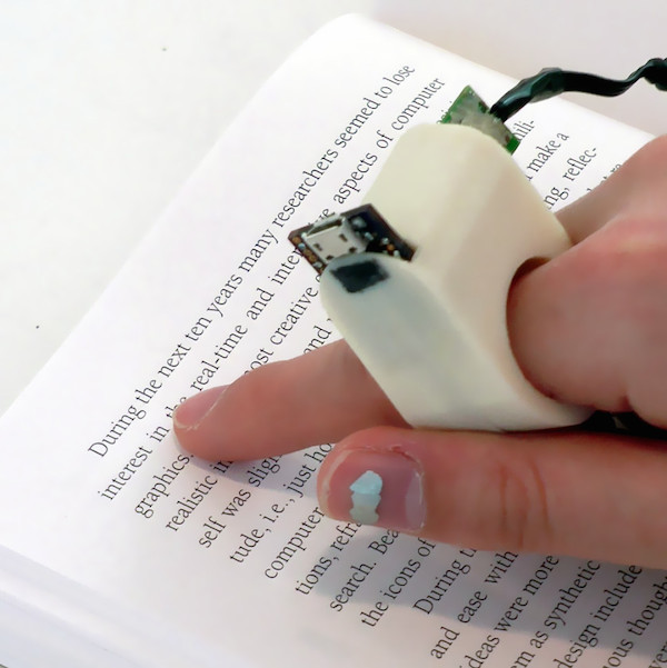 It's a 3D-printed device that uses the attached camera to recognize and read text for the user.